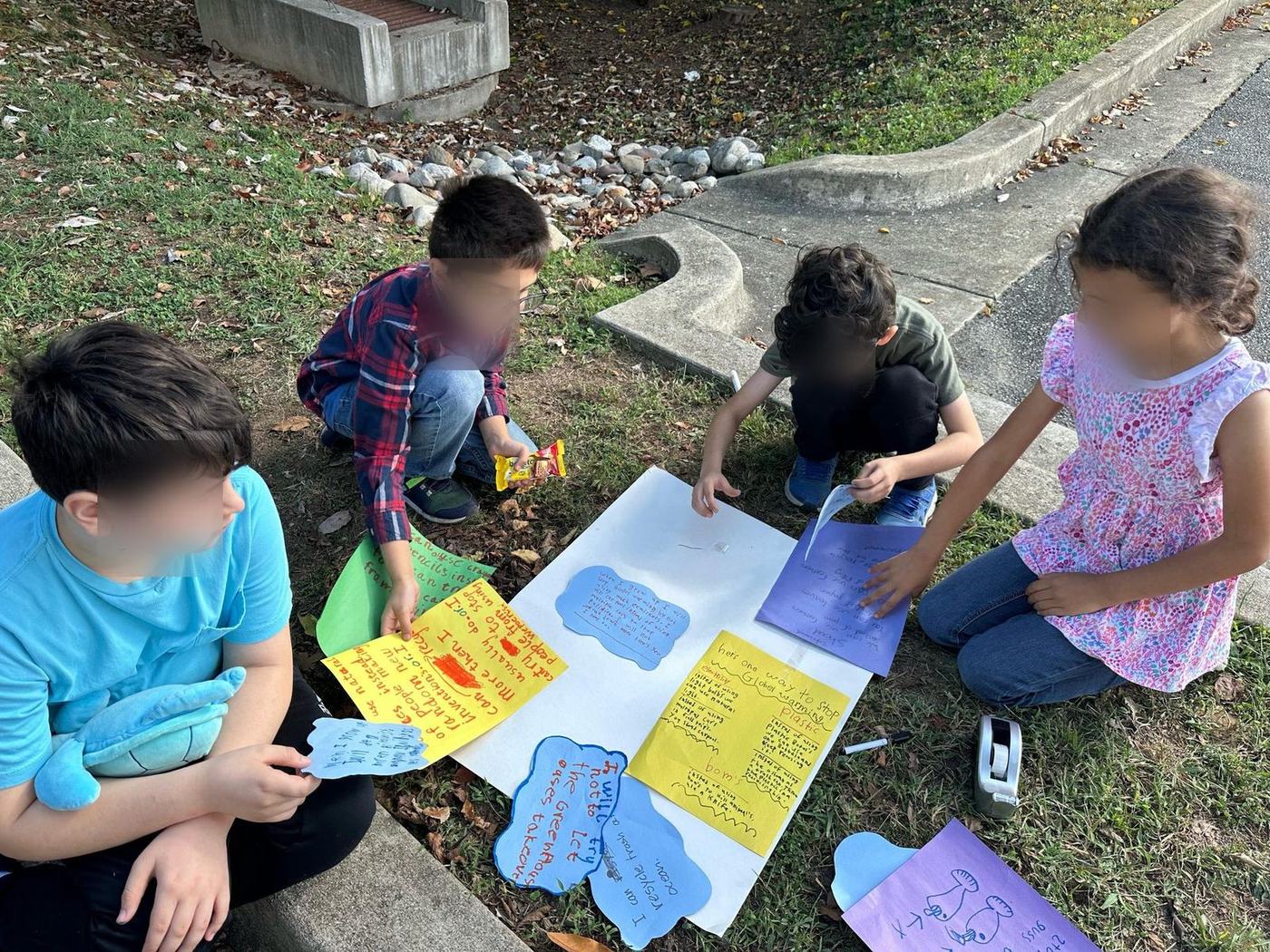 Students assembling a poster project about stopping global warming outdoors